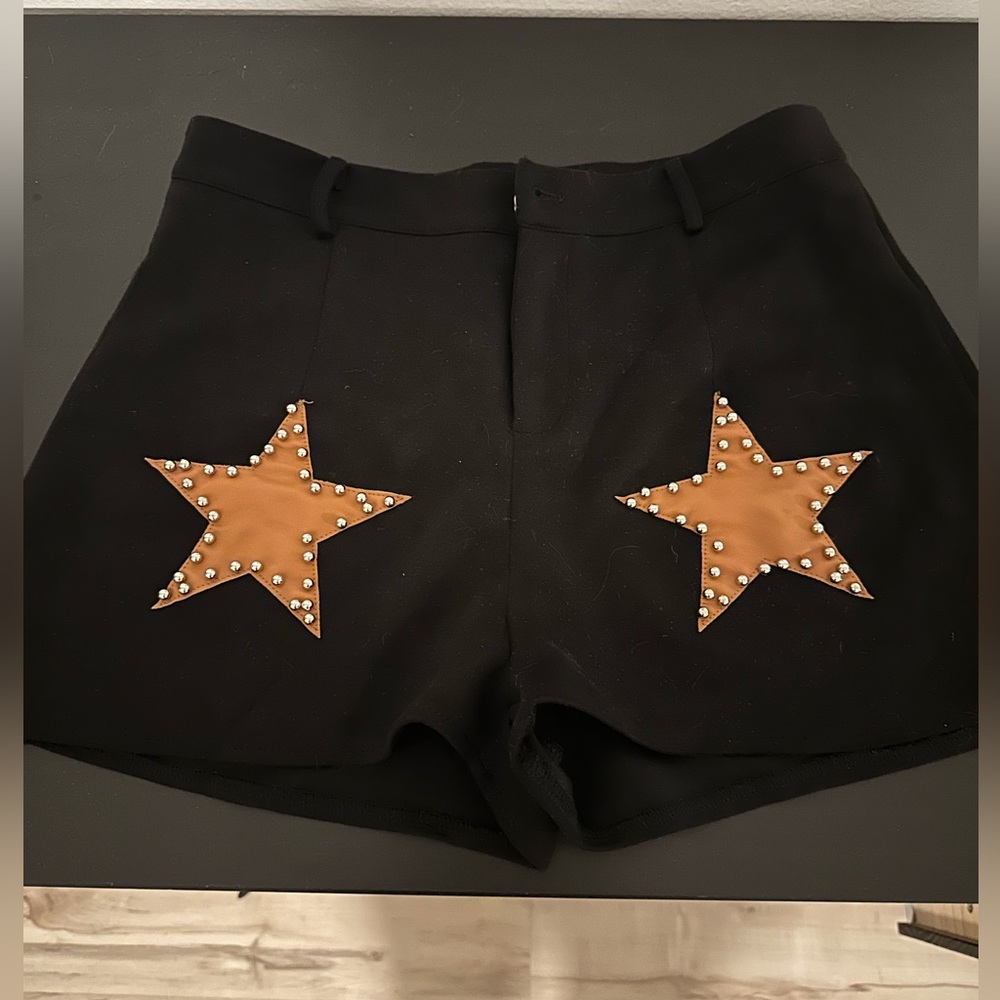 Black suede/polyester shorts with gold stars on the front